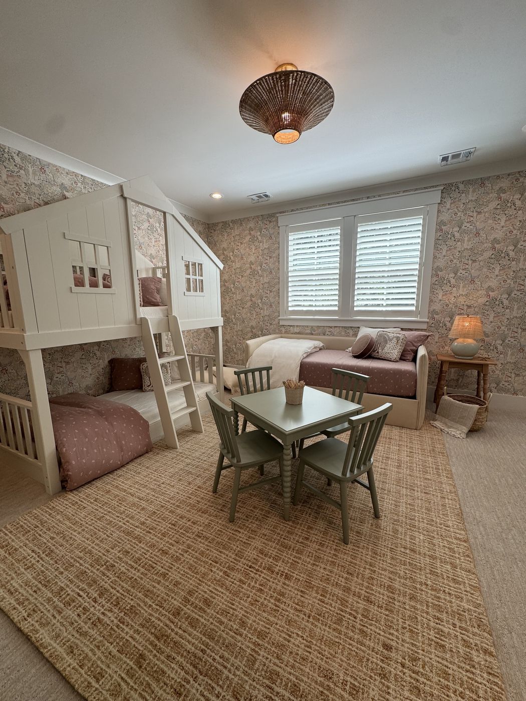 Bunk room with daybed, polka-dot bedding, and woven pendant