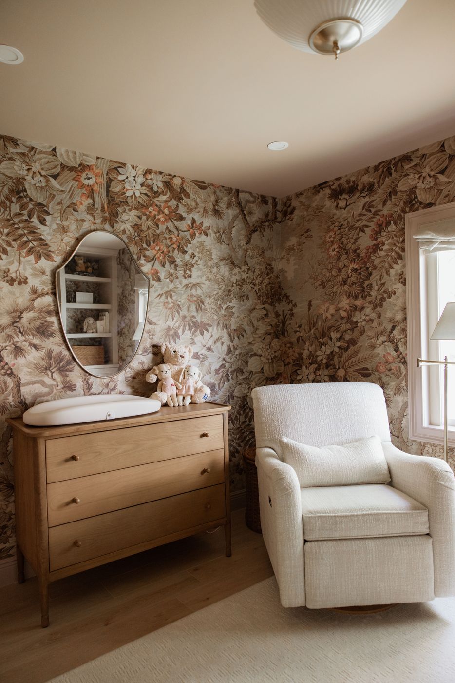 Nursery corner with oak dresser, changing pad, and plush toys